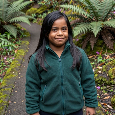 Priya, a UX designer with hypochondroplasia on an accessible Oregon forest trail