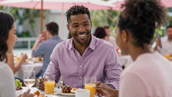 ADHD man laughing animatedly with his partner at a sunlit brunch